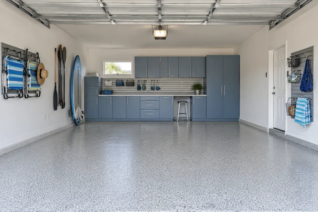 The same garage imagined with coastal blue-gray cabinetry, organized beach gear and a light flake floor