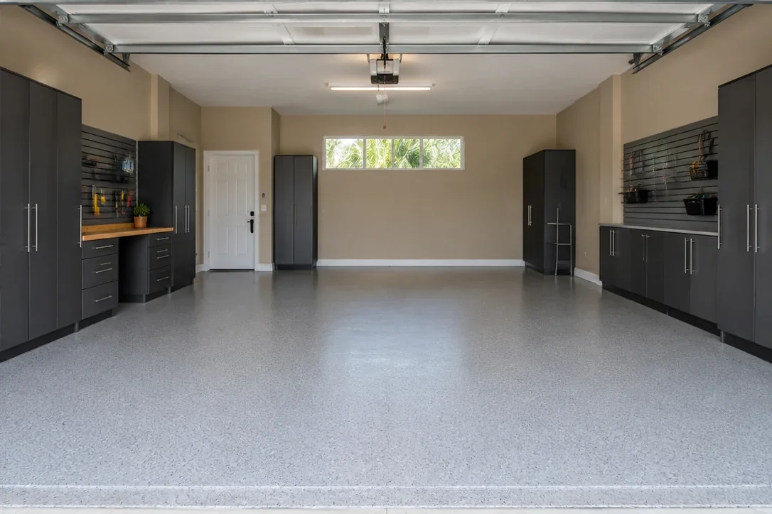 The same large garage imagined with a light flake floor, charcoal cabinets and a wood workbench